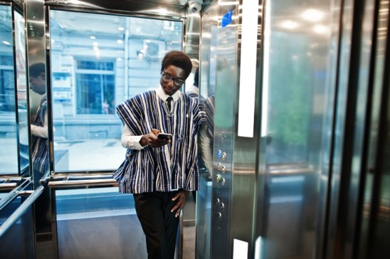 Man uses his phone in a lift